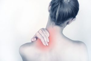Image of a woman back touching a painful area near her neck
